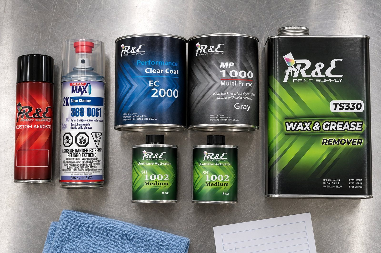 Ordering your paint code in the right size: aerosol basecoat, 2K clear aerosol, quart paint kit and wax and grease remover laid out on a shop bench